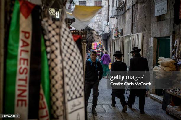 Jewish men pass a store selling Palestinian clothing in the Muslim Quarter of the Old City on December 10, 2017 in Jerusalem, Israel. In an already...