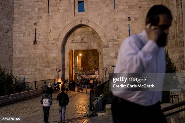 Jewish man speaks on the phone as he leaves the Damscus Gate at the Old City on December 10, 2017 in Jerusalem, Israel. In an already divided city,...