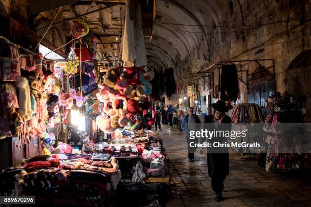 Jewish man speaks on the phone as he passes stores at an entrance to the Al-Aqsa Mosque in the Old City on December 10, 2017 in Jerusalem, Israel. In...