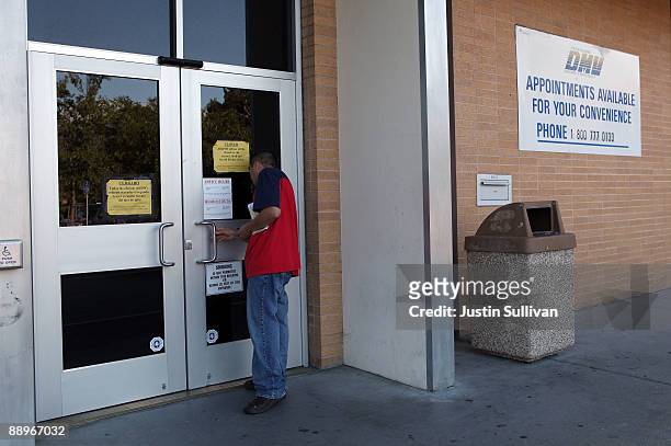 California Department of Motor Vehicles customer peers into the door of a closed DMV branch July 10, 2009 in Corte Madera, California. As California...
