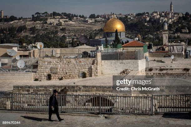 Jewish man walks along the rooftops of a market in front of the Al-Aqsa Mosque on December 10, 2017 in Jerusalem, Israel. In an already divided city,...