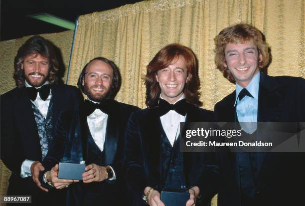 The Bee Gees pose with Barry Manilow at the American Music Awards, 18th January 1979. From left to right, Barry Gibb, Maurice Gibb , Robin Gibb and...