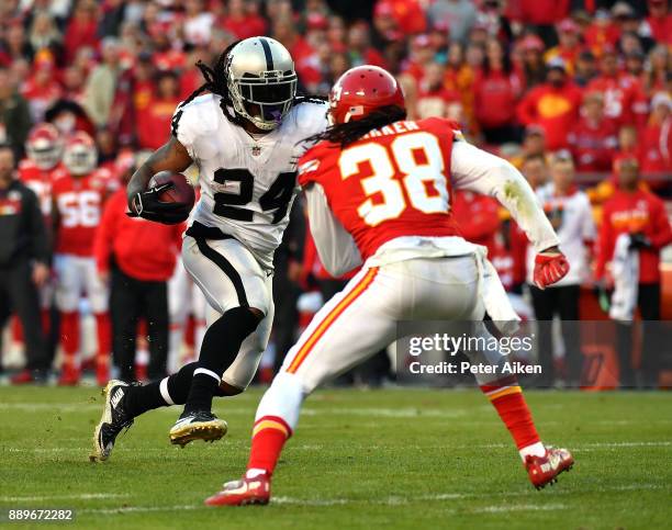 Running back Marshawn Lynch of the Oakland Raiders carries the ball as free safety Ron Parker of the Kansas City Chiefs defends during the game at...