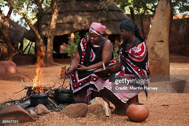 shangaan women cooking around a fire. - south african culture stock pictures, royalty-free photos & images