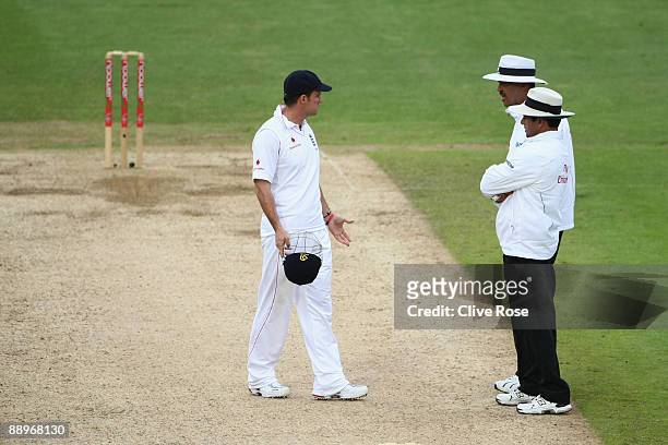 Andrew Strauss of England talks to match Umpires Billy Doctrove and Allem Dar after the light is taken by Australia during day three of the npower...