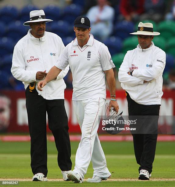 Andrew Strauss of England walks off with umpires Billy Doctrove and Aleem Dar after play was suspended during day three of the npower 1st Ashes Test...