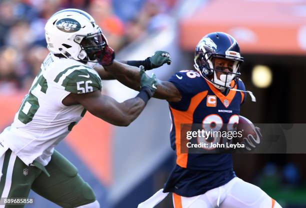 Denver Broncos wide receiver Demaryius Thomas straight arms New York Jets inside linebacker Demario Davis after a catch during the first quarter on...