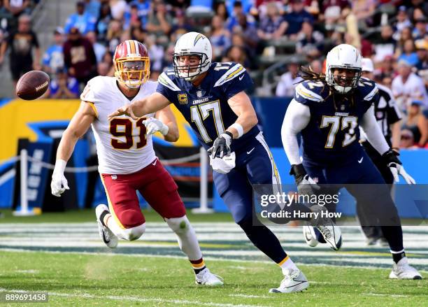 Philip Rivers of the Los Angeles Chargers scrambles out of the pocket away from Ryan Kerrigan as he passes during the first quarter at StubHub Center...