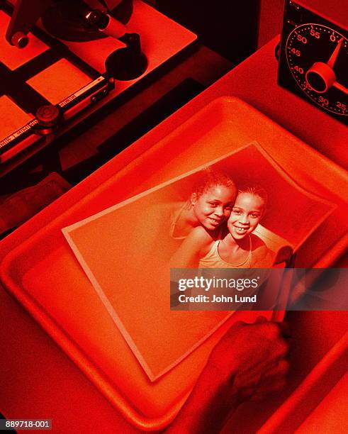 picture of two girls (9-12) being developed in darkroom (composite) - donkere kamer stockfoto's en -beelden
