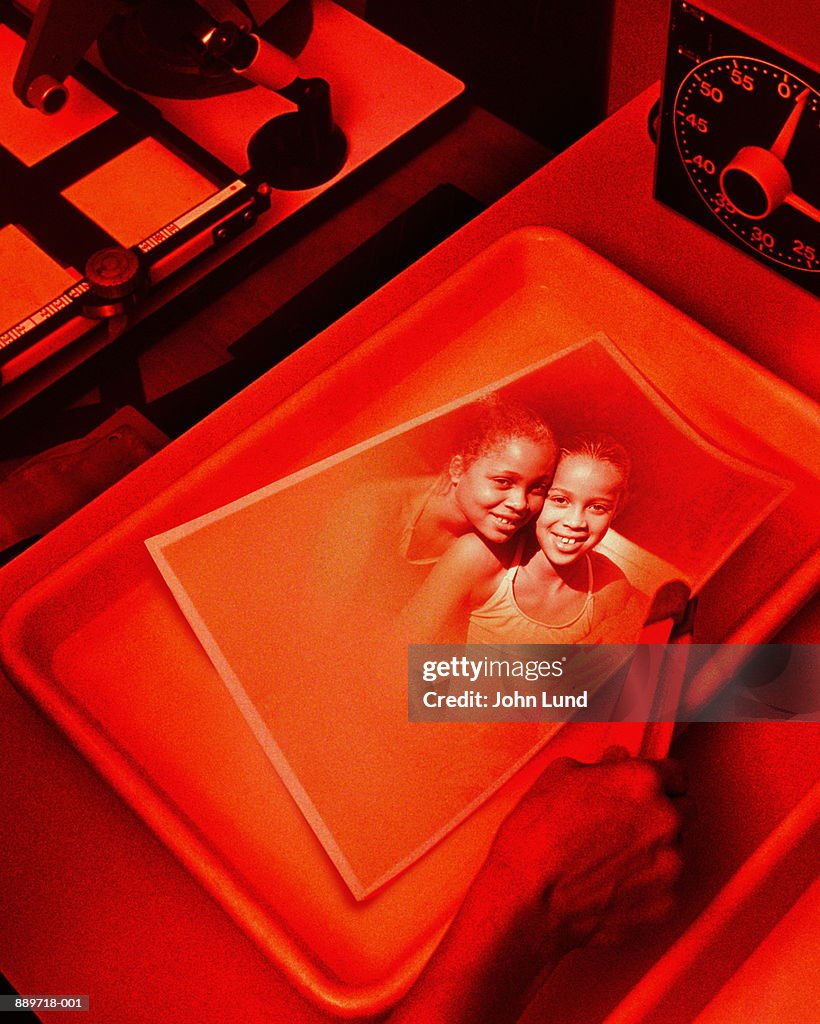 Picture of two girls (9-12) being developed in darkroom (Composite)