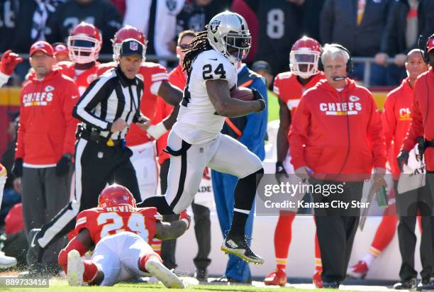 Oakland Raiders running back Marshawn Lynch flies past Kansas City Chiefs defensive back Darrelle Revis in the first quarter for a first down on...