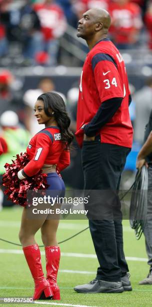 Honorary cheerleader Simone Biles and Homefield Advantage Captain Hakeem Olajuwon during a game between the San Francisco 49ers v Houston Texans at...