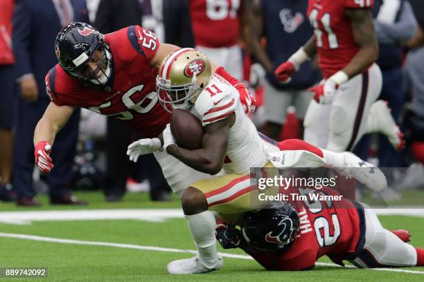 Marquise Goodwin of the San Francisco 49ers is tackled by Brian Cushing of the Houston Texans and Andre Hal in the second quarter at NRG Stadium on...