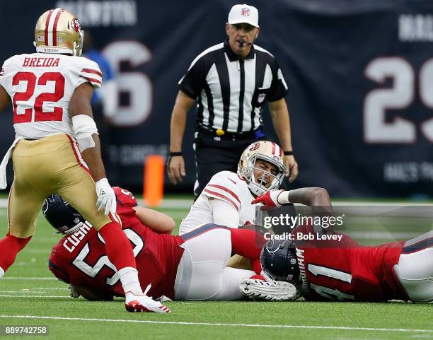 Jimmy Garoppolo of the San Francisco 49ers is sacked by Brian Cushing of the Houston Texans and Zach Cunningham in the second half at NRG Stadium on...