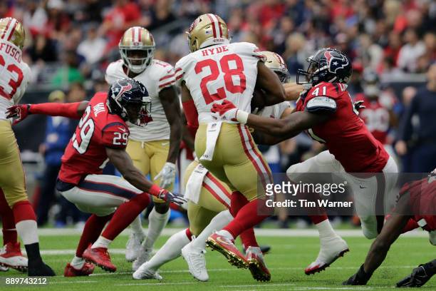 Carlos Hyde of the San Francisco 49ers is wrapped up by Zach Cunningham of the Houston Texans in the first half at NRG Stadium on December 10, 2017...