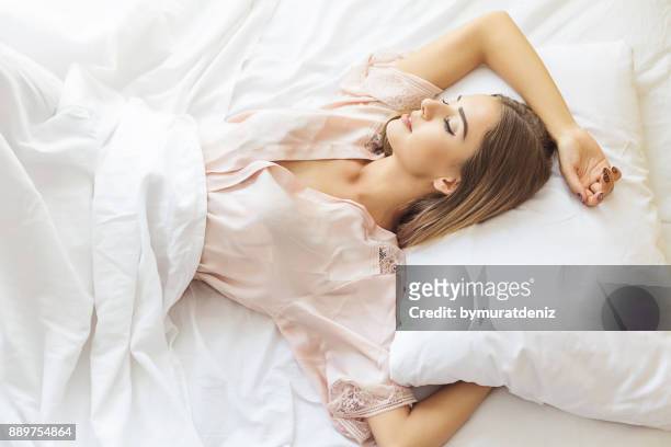 jeune femme endormie - vêtement de nuit photos et images de collection