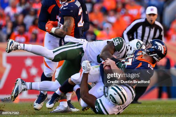 Quarterback Trevor Siemian of the Denver Broncos is sacked by Demario Davis and outside linebacker David Bass of the New York Jets at Sports...