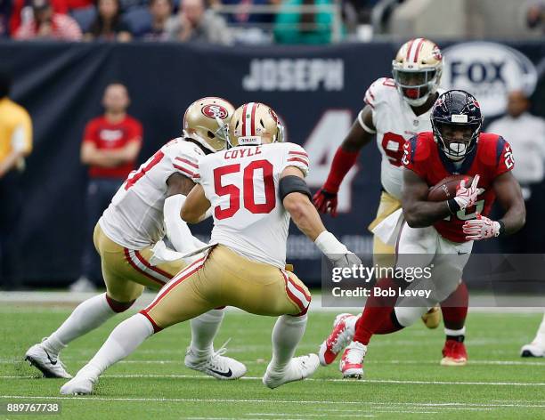 Lamar Miller of the Houston Texans rushes with the ball as Brock Coyle of the San Francisco 49ers looks to make a tackle at NRG Stadium on December...