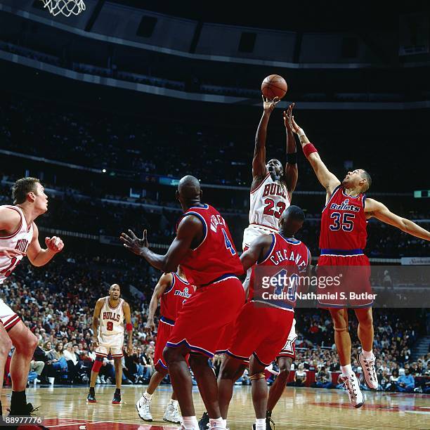 Michael Jordan of the Chicago Bulls goes up for a shot against Chris Webber, Calbert Cheaney and Tracy Murray of the Washington Bullets in Game Two...