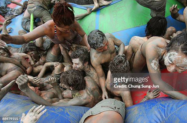 Participants enjoy mud during the 12th Annual Boryeong Mud Festival at Daecheon Beach on July 11, 2009 in Boryeong, South Korea. The annual mud...