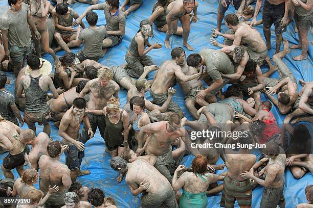 Participants enjoy mud during the 12th Annual Boryeong Mud Festival at Daecheon Beach on July 11, 2009 in Boryeong, South Korea. The annual mud...