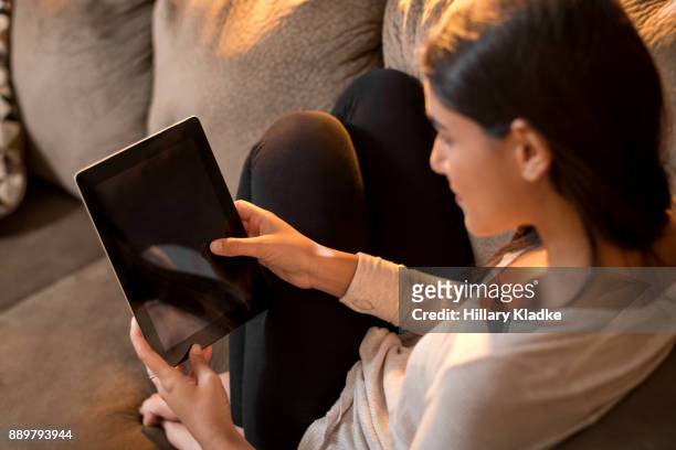 woman sits on couch with tablet - tablet screen home stock-fotos und bilder