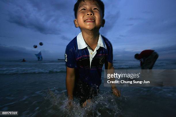Boy enjoys the water on the beach during the 12th Annual Boryeong Mud Festival at Daecheon Beach on July 11, 2009 in Boryeong, South Korea. The...