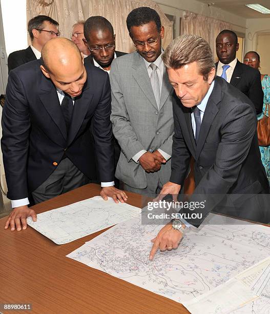 French State Secretary for Cooperation Alain Joyandet points at a map with technician Youssouf Mohamat as he visits with Senegalese Transport...