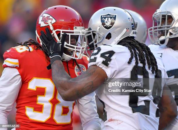 Oakland Raiders running back Marshawn Lynch pats Kansas City Chiefs free safety Ron Parker on the helmet after avoiding Parker's tackle and scoring...