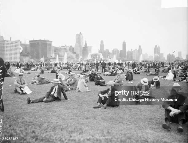 View of crowds sitting and standing on a lawn in Grant Park in the Loop community area of Chicago, Illinois, on August 28 to watch the Graf Zeppelin...