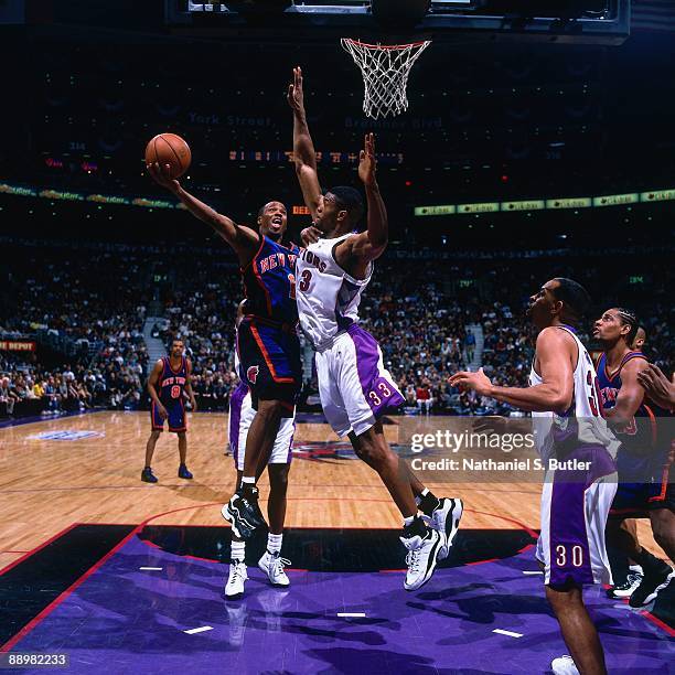 Chris Childs of the New York Knicks shoots a layup against Antonio Davis of the Toronto Raptors in Game Three of the Eastern Conference Quarterfinals...