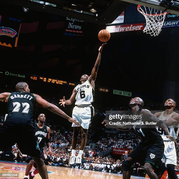 Avery Johnson of the San Antonio Spurs shoots a layup against Dean Garrett and Kevin Garnett of the Minnesota Timberwolves in Game Two of the Western...