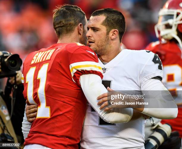 Quarterback Derek Carr of the Oakland Raiders exchanges words and a hug with quarterback Alex Smith of the Kansas City Chiefs following the game at...