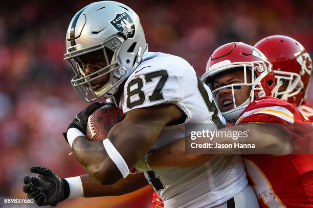 Tight end Jared Cook of the Oakland Raiders fights through the tackle attempt of strong safety Daniel Sorensen of the Kansas City Chiefs for a...