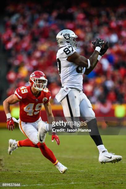 Tight end Jared Cook of the Oakland Raiders hauls in a pass that would lead to a touchdown in front of the coverage of strong safety Daniel Sorensen...