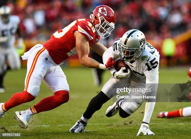 Strong safety Daniel Sorensen of the Kansas City Chiefs attempts to punch out the ball from wide receiver Michael Crabtree of the Oakland Raiders...