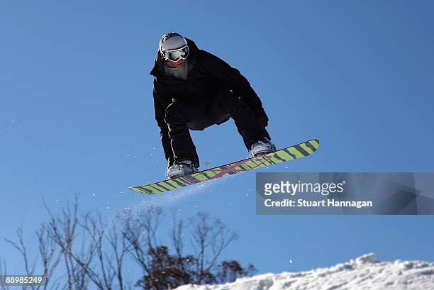 Snowboarder glides thru the air whilst enjoying the terrain park leading off the high noon run at Thredbo ski resort on July 8, 2009 in Thredbo,...