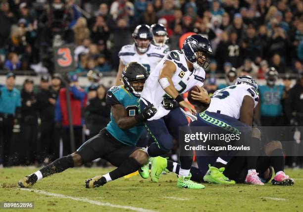 Russell Wilson of the Seattle Seahawks is tackled by Yannick Ngakoue of the Jacksonville Jaguars during the second half of their game at EverBank...