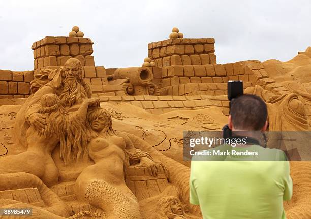 Tourist takes a photograph of a sand sculpture during the annual sand sculpture festival on July 11, 2009 in Blankenberge, Belgium.