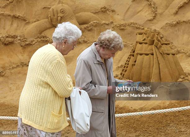 Two women attend the annual sand sculpture festival on July 11, 2009 in Blankenberge, Belgium.