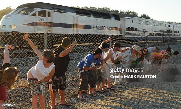 Residents of Laguna Niguel expose their buttocks during the 30th annual "Mooning of the trains" event along a stretch of railroad track in Orange...