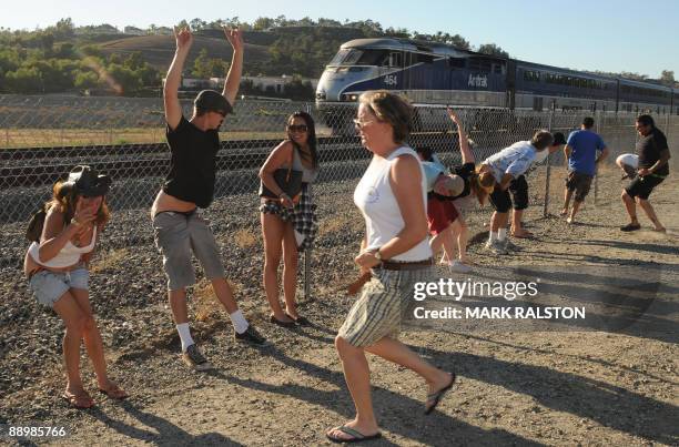 Residents of Laguna Niguel expose their buttocks during the 30th annual "Mooning of the trains" event along a stretch of railroad track in Orange...
