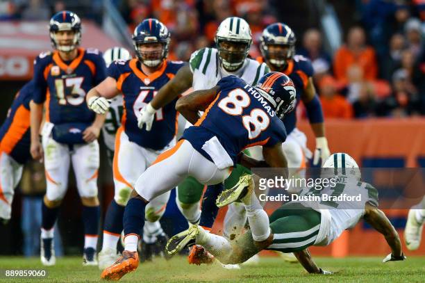 Wide receiver Demaryius Thomas of the Denver Broncos is stopped by cornerback Buster Skrine of the New York Jets after a fourth quarter catch at...