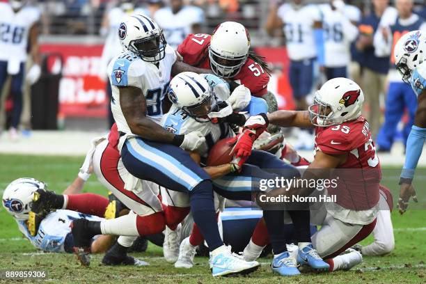 Eric Weems of the Tennessee Titans is tackled by Josh Bynes and Elijhaa Penny of the Arizona Cardinals in the second half at University of Phoenix...