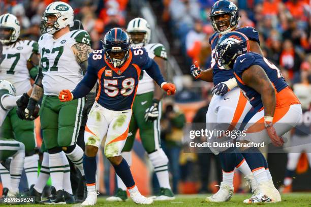 Outside linebacker Von Miller of the Denver Broncos celebrates along with Shelby Harris and Leonard Williams after a sack against the New York Jets...