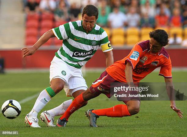 Scott McDonald of Celtic is tackled by Adam Sarota of the Roar during the pre-season friendly match between the Brisbane Roar and Celtic FC at...