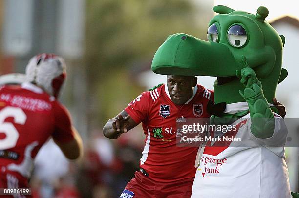 Jamie Soward of the Dragons pretends to take a photo of team mate Wendell Sailor and the Dragons mascot after Sailor scored his second try during the...