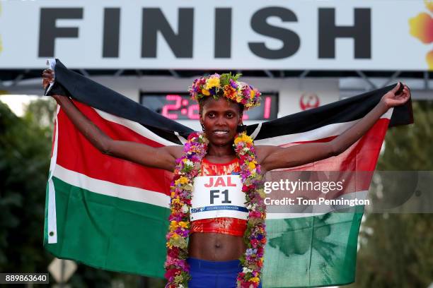 Bridgid Kosei of Kenya poses with a flag after winning the Women's division of the Honolulu Marathon 2017 on December 10, 2017 in Honolulu, Hawaii.