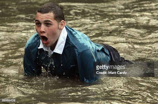 Royal Navy recruit gasps as he gets in the water in the harbour at the Piers Cellars training centre as he takes part in team-building exercise close...
