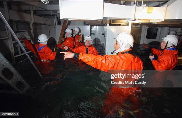 Royal Navy recruits try to stem the flow of flood water in a sinking ship simulator known as a Damage Repair Instructional Unit or HAVOC at the...